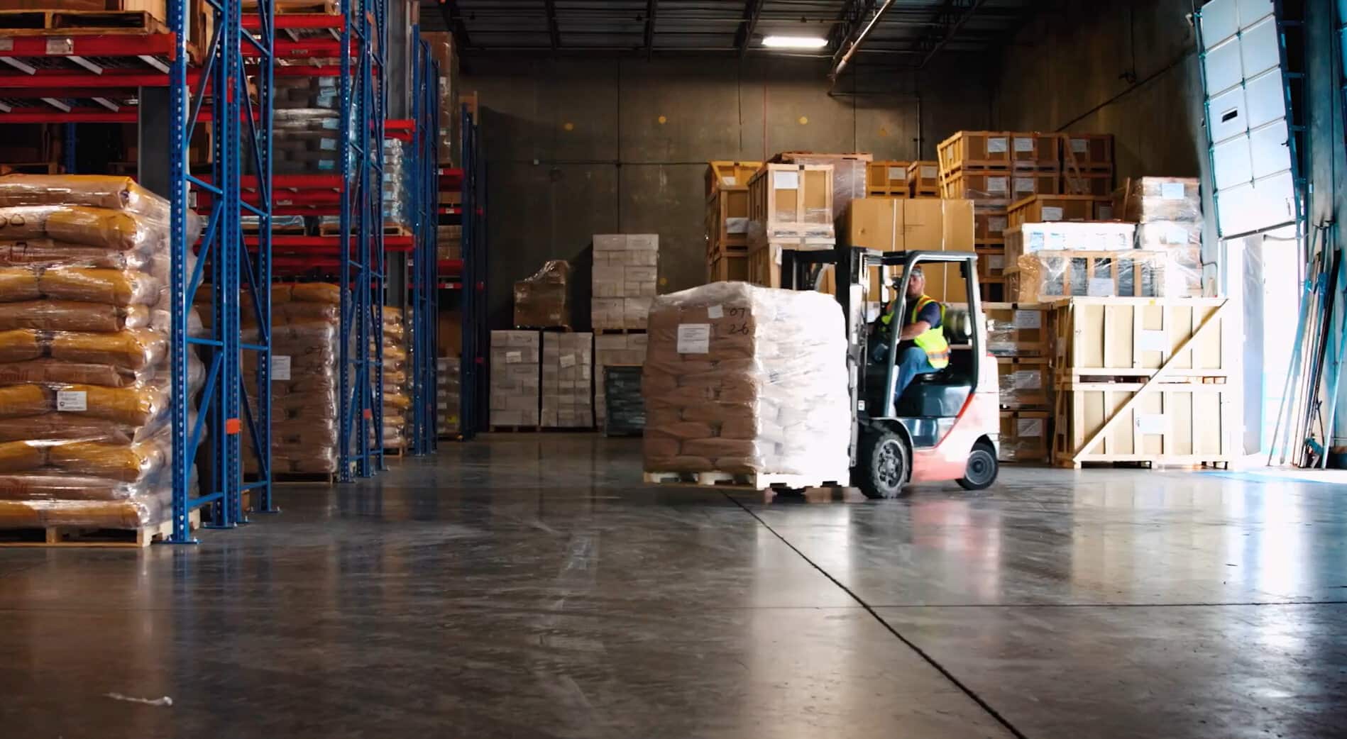 Person on a skid loader moving merchandise in a warehouse