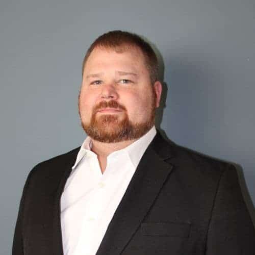 Sam Hackworth - Man dressed in a black suit and white shirt